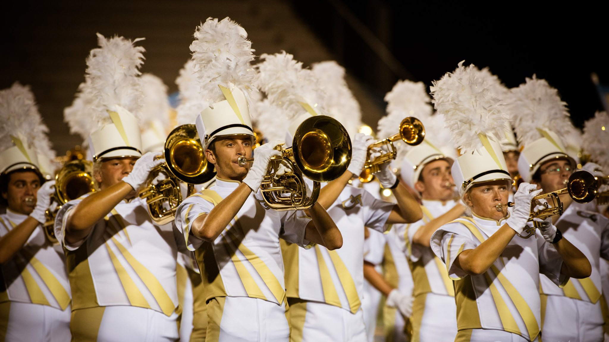 A group of brass players in the middle of a routine.